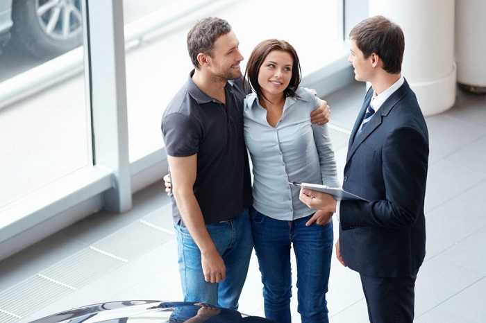 Couple talking to a salesperson at a Mazda dealership