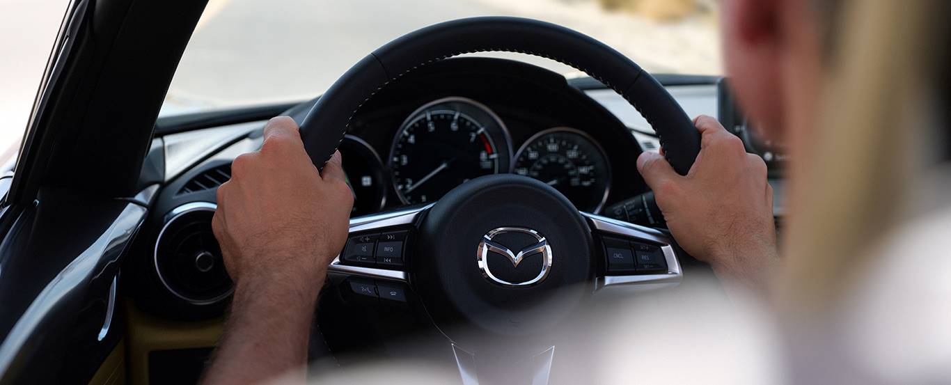 Person driving a vehicle equipped with Mazda safety features