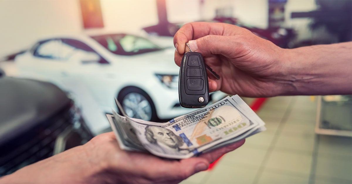 Cash and keys exchanging hands as part of Mazda trade-in